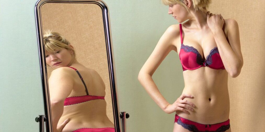 The girl looks at her reflection in the mirror